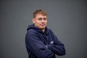 Porträtfoto - Joel in dunkelblauem Firmen-Kapuzenpullover