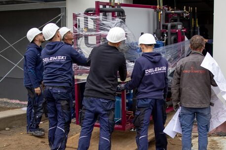 Monteure beim Aufbau einer industriellen Kühlanlage auf einer Baustelle.