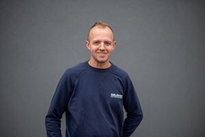 Porträtfoto - Bartek in dunkelblauem Firmenpullover